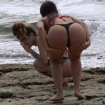 Girls Squatting And Bending at The Beach
